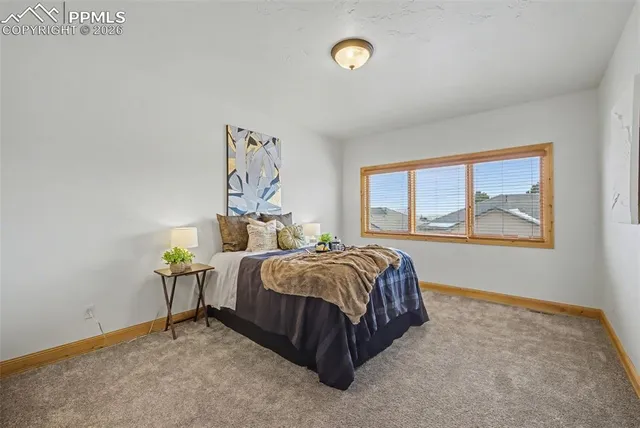 a bed sitting in a bedroom next to a window