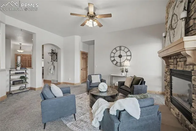 a living room with furniture a fireplace and a chandelier