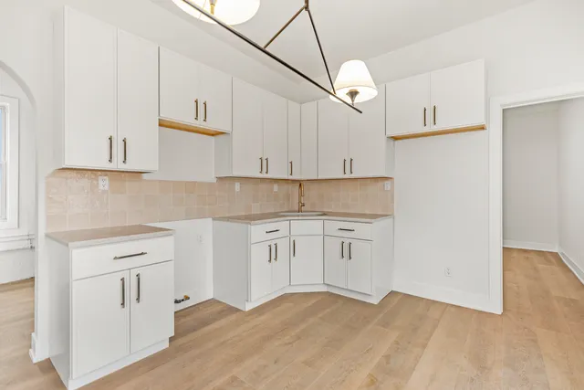 a kitchen with granite countertop white cabinets and white appliances