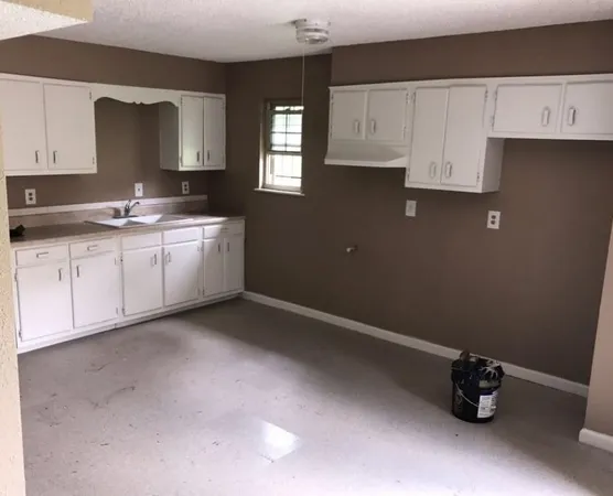 a kitchen with a sink cabinets and a window