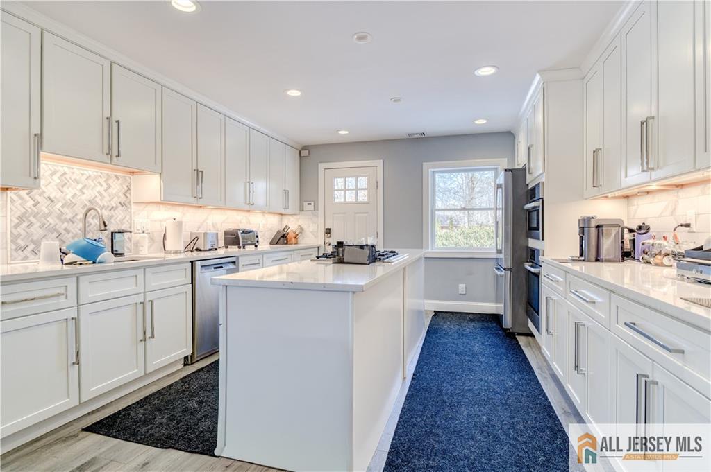 176 Old Forge Road Monroe Township, NJ 08831 - Photo 7 of 36 a kitchen with white cabinets sink and white appliances