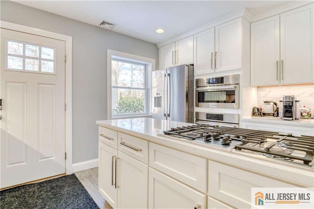 176 Old Forge Road Monroe Township, NJ 08831 - Photo 9 of 36 a kitchen with white cabinets and appliances
