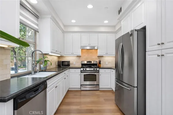 a bathroom with a granite countertop sink and a window