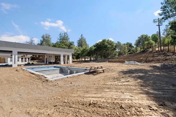 a view of pool with two chairs and a yard