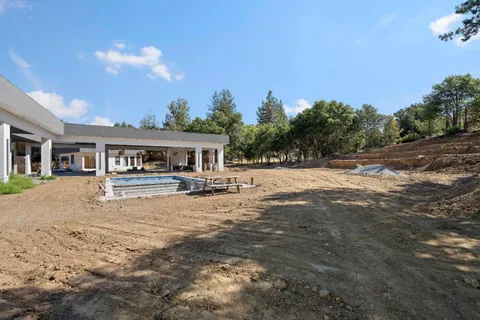 a front view of a house with a yard and trees