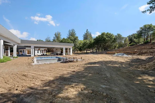 a front view of a house with a yard and trees