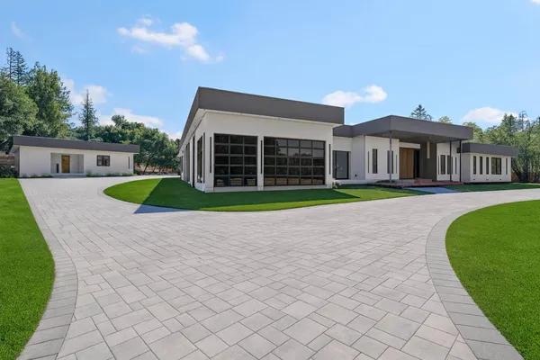 a view of a house with a yard and large trees