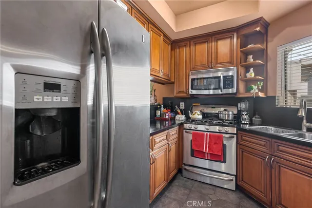a kitchen with granite countertop a refrigerator stove and sink