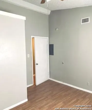 a view of an empty room with wooden floor