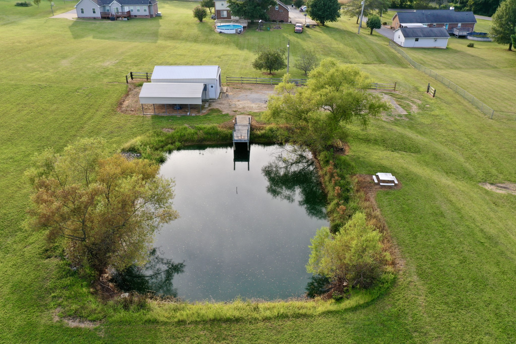 654 Denning Ford Road Portland, TN 37148 - Photo 37 of 39 a view of a lake with lawn chairs and a fountain