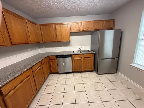 a kitchen with stainless steel appliances a sink refrigerator and microwave
