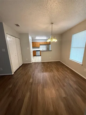 a view of a room with wooden floor ceiling fan and window