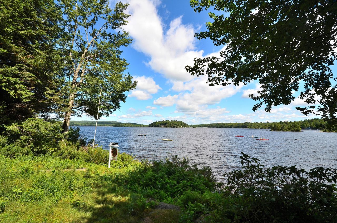405 Stanley Road Otis, MA 01029 - Photo 8 of 16 a view of a lake with beach and large trees