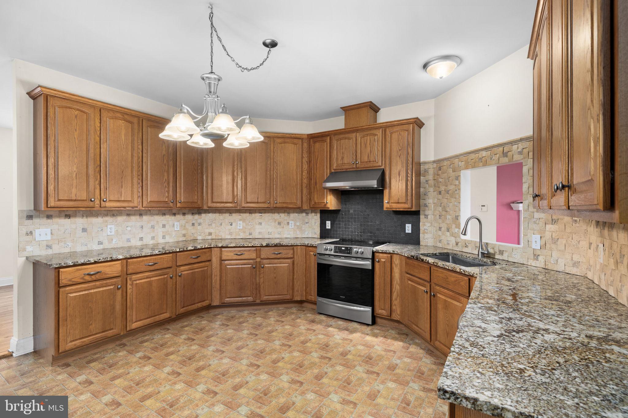 2481 Yanceyville Road Louisa, VA 23093 - Photo 15 of 66 a kitchen with stainless steel appliances granite countertop a sink stove and refrigerator