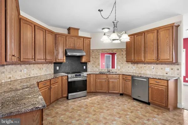 a kitchen with granite countertop a sink and a stove