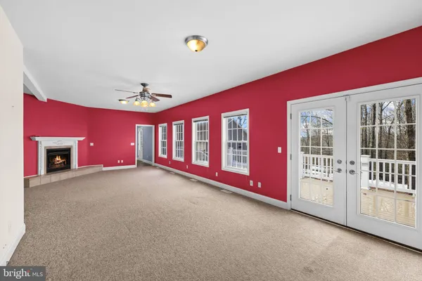 a view of a livingroom with a ceiling fan and kitchen space