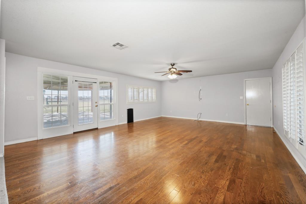 891 HCR 2124 Loop Whitney, TX 76692 - Photo 23 of 40 an empty room with wooden floor and windows