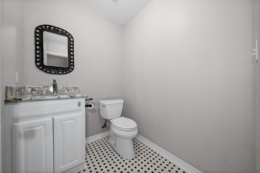 891 HCR 2124 Loop Whitney, TX 76692 - Photo 24 of 40 a bathroom with a toilet sink vanity and mirror