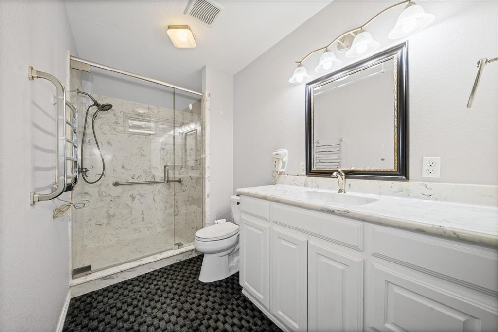 891 HCR 2124 Loop Whitney, TX 76692 - Photo 26 of 40 a bathroom with a granite countertop sink toilet a mirror a vanity and shower