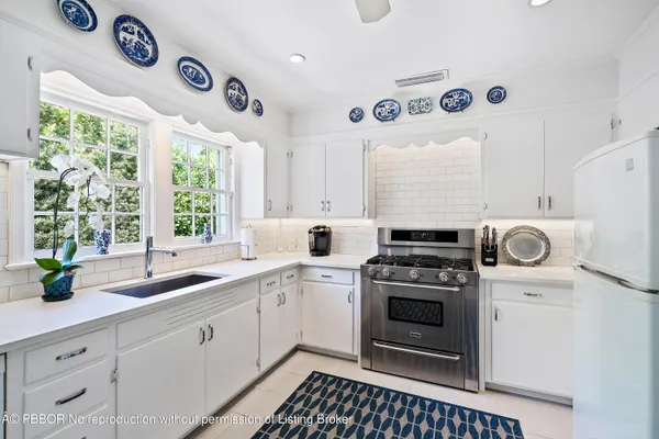 a kitchen with a stove a sink and a window
