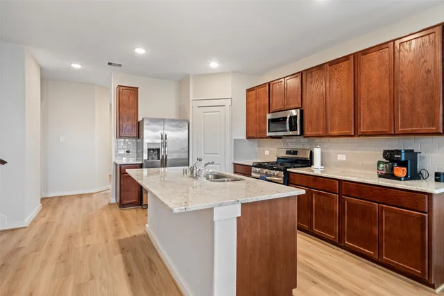 a kitchen with stainless steel appliances granite countertop a sink stove and microwave