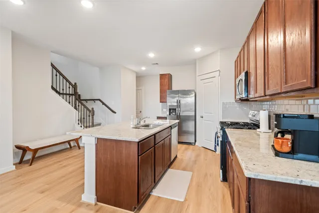 a kitchen with stainless steel appliances granite countertop a sink stove and refrigerator