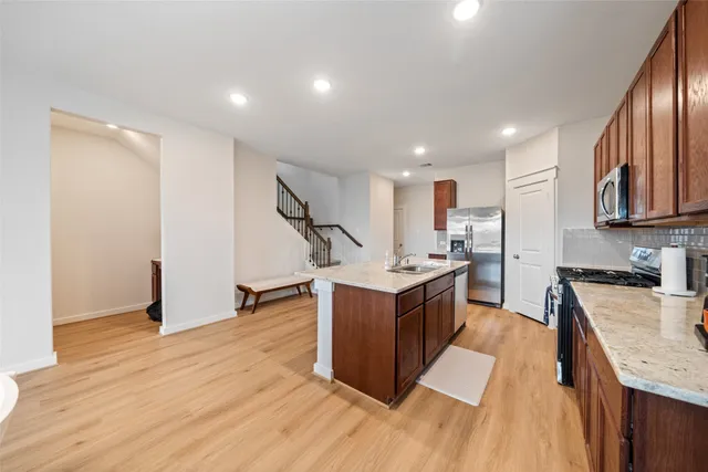 a kitchen with stainless steel appliances granite countertop a sink stove and refrigerator