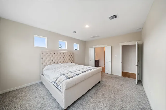 a spacious bedroom with a bed and a dresser