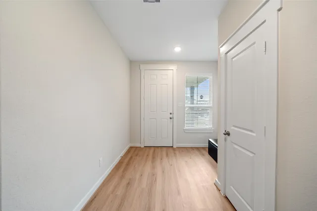 a view of a room with wooden floor and white walls