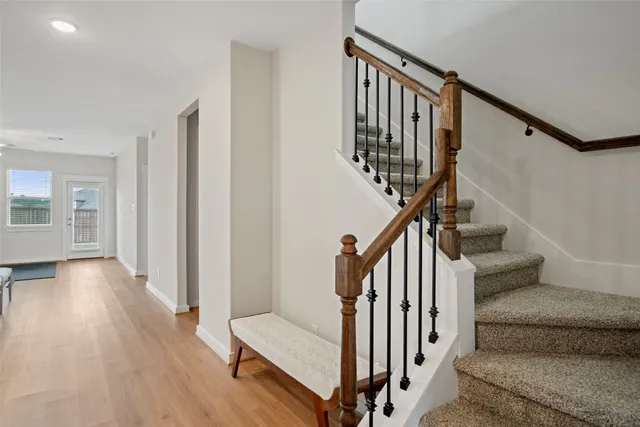 a view of staircase with wooden floor and white walls
