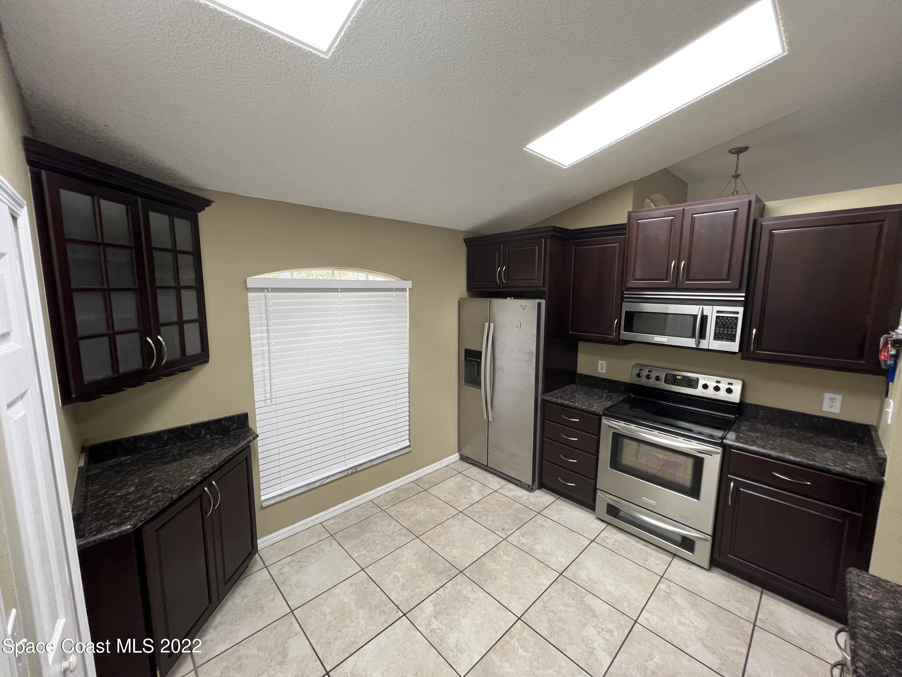 1873 Cleveland Street Northeast Palm Bay, FL 32905 - Photo 11 of 28 a kitchen with stainless steel appliances granite countertop a refrigerator stove and sink