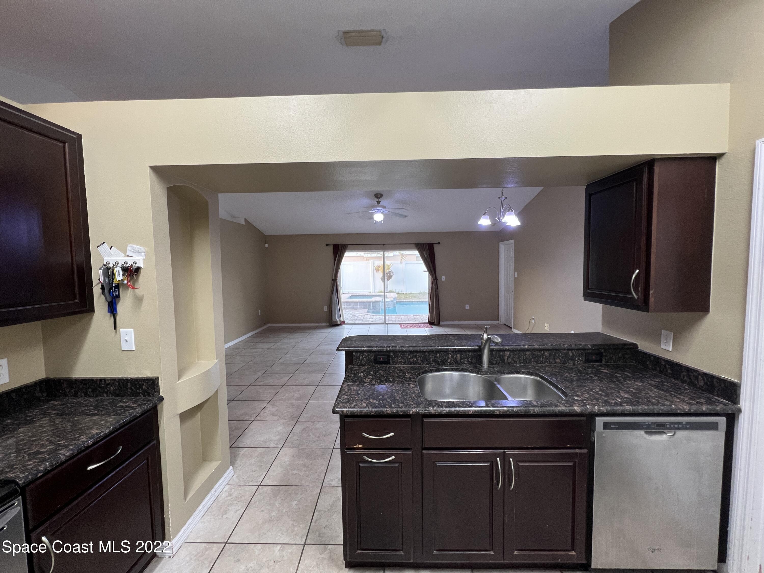 1873 Cleveland Street Northeast Palm Bay, FL 32905 - Photo 13 of 28 a kitchen with granite countertop a sink and a stove