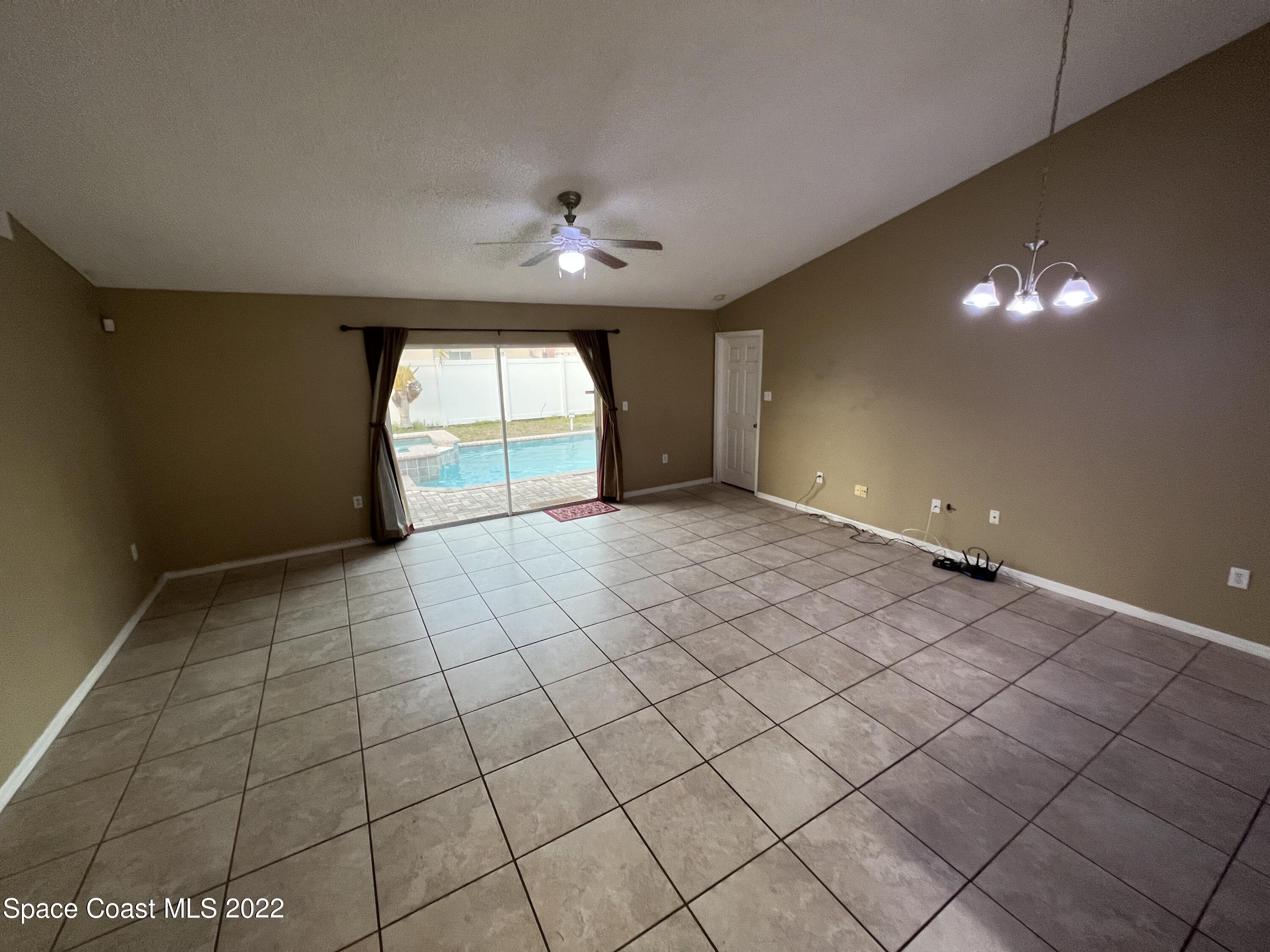 1873 Cleveland Street Northeast Palm Bay, FL 32905 - Photo 14 of 28 an empty room with windows and fan