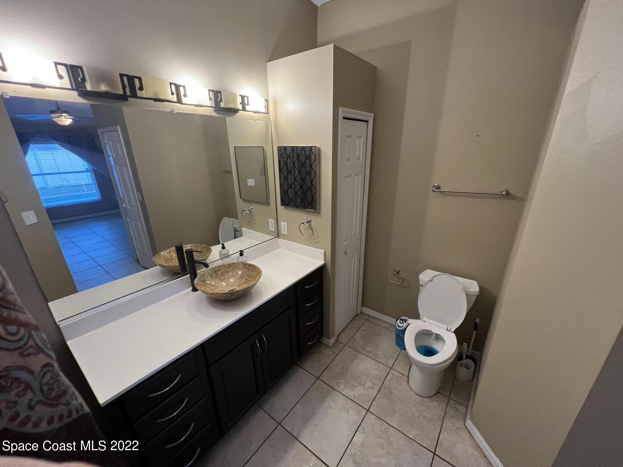 1873 Cleveland Street Northeast Palm Bay, FL 32905 - Photo 17 of 28 a bathroom with a sink vanity and mirror