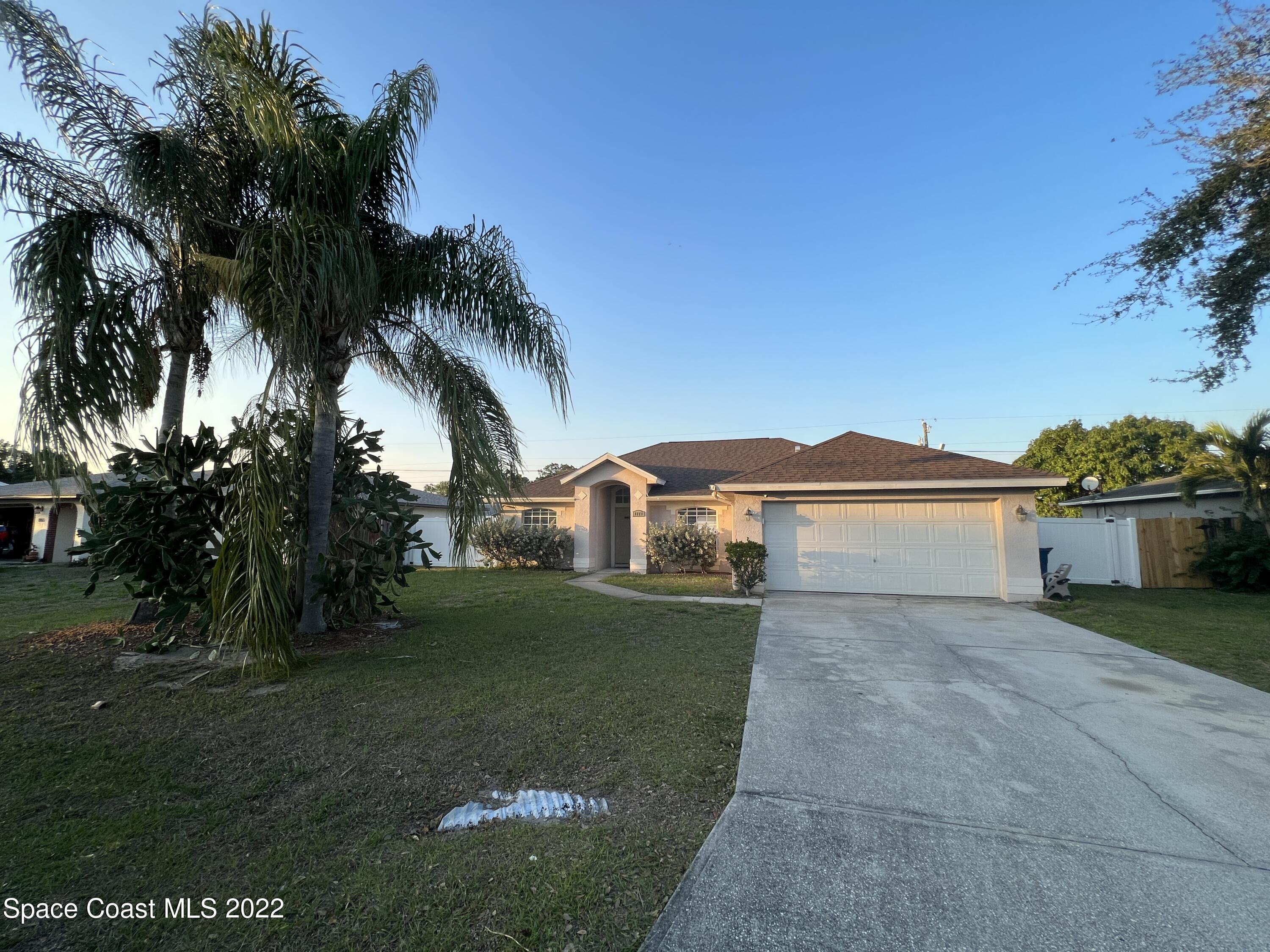 1873 Cleveland Street Northeast Palm Bay, FL 32905 - Photo 2 of 28 a view of house with a yard and a large tree