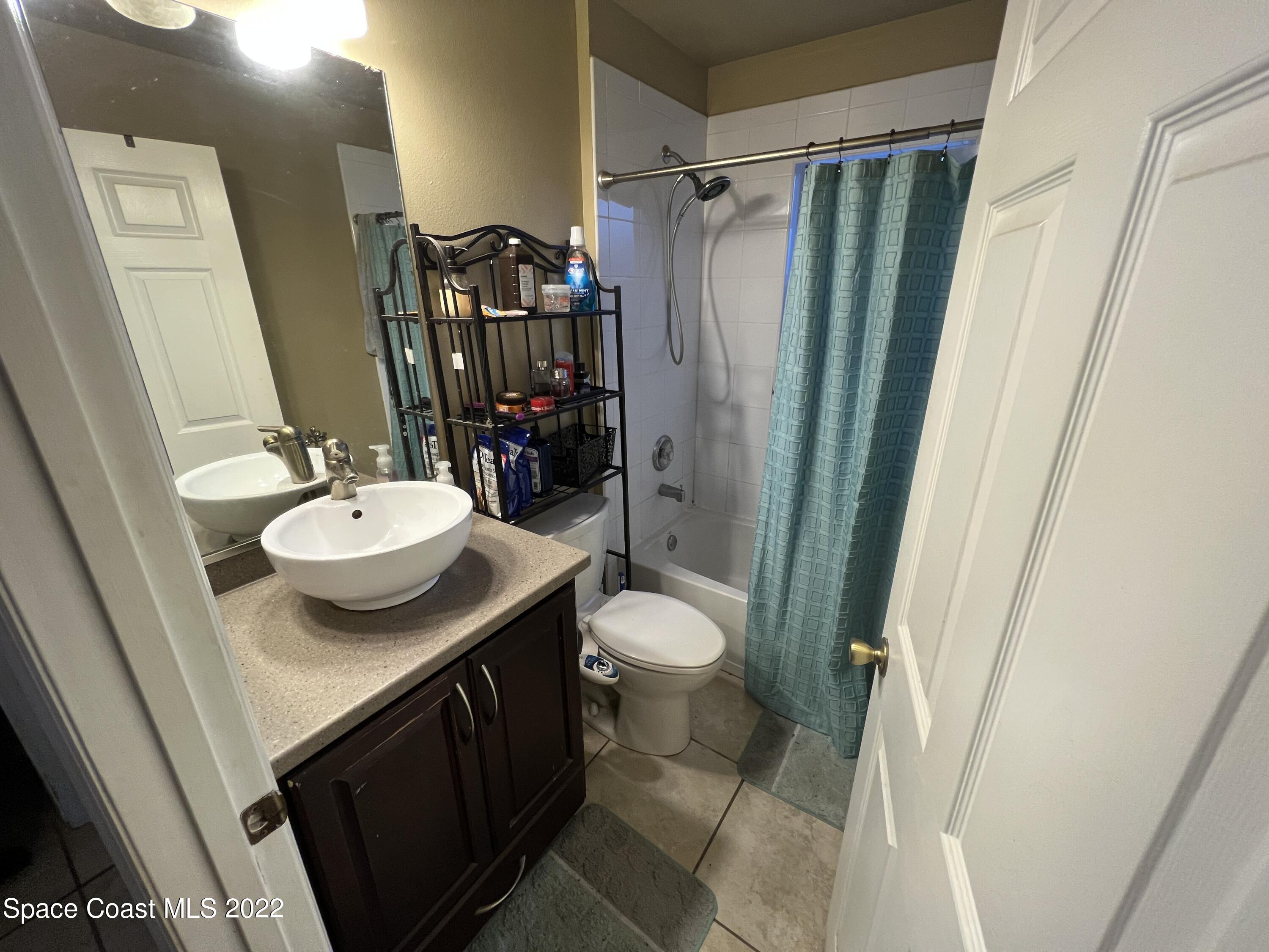 1873 Cleveland Street Northeast Palm Bay, FL 32905 - Photo 21 of 28 a bathroom with a sink toilet and shower