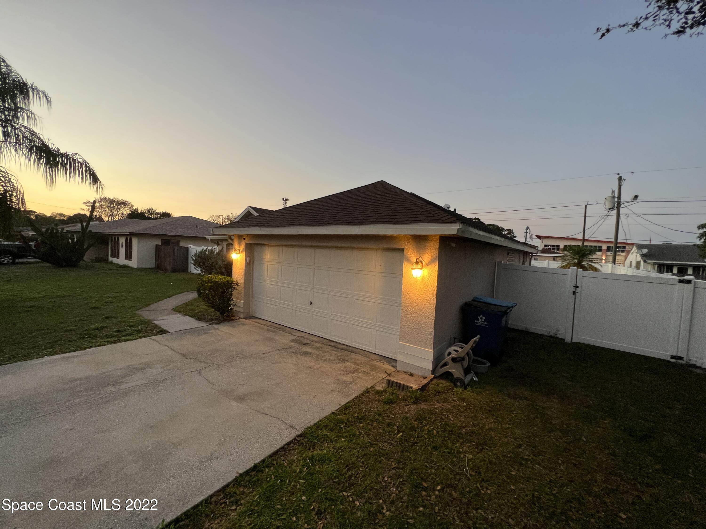 1873 Cleveland Street Northeast Palm Bay, FL 32905 - Photo 4 of 28 a backyard of a house with a yard and garage
