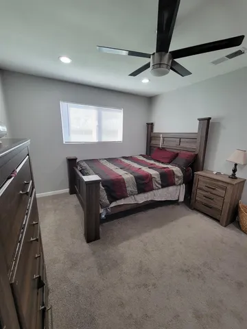 a spacious bedroom with a bed and a ceiling fan
