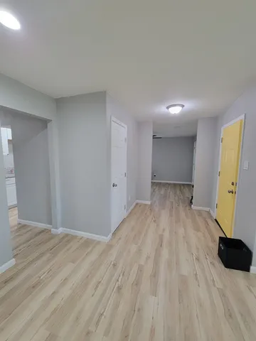 a workspace with wooden floor a chandelier fan and a window