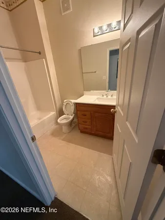 a bathroom with a tub sink and mirror