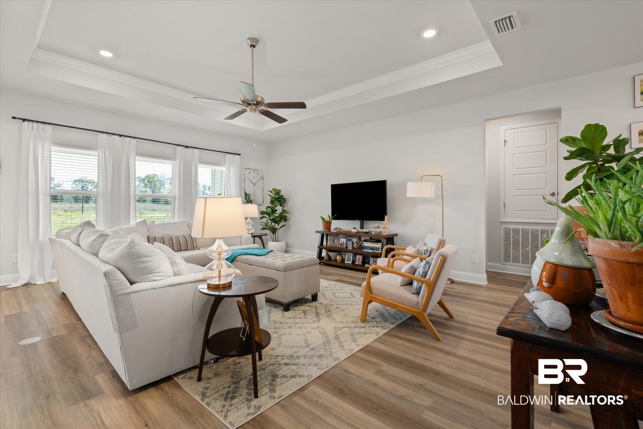 1167 Provision Road Mobile, AL 36608 - Photo 3 of 20 Living room with visible vents, light wood-type flooring, a raised ceiling, and baseboards