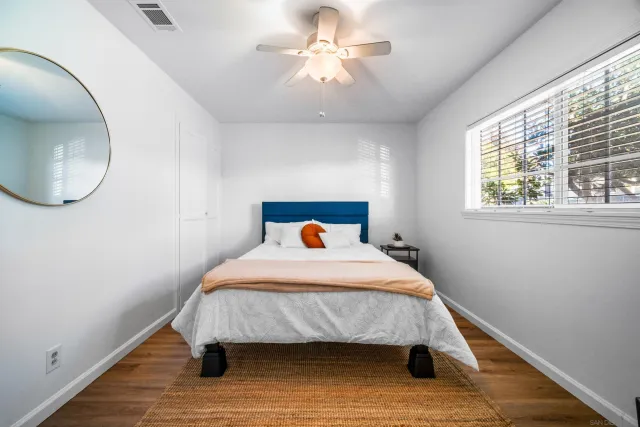 a bed sitting in a bedroom next to a window