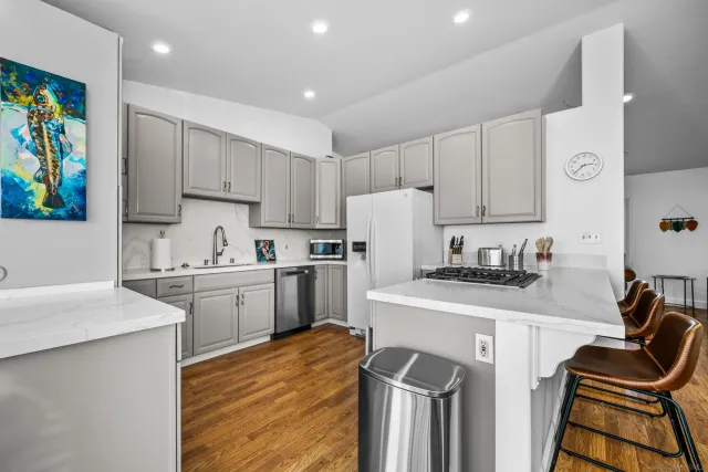 a kitchen with granite countertop a sink stove and refrigerator