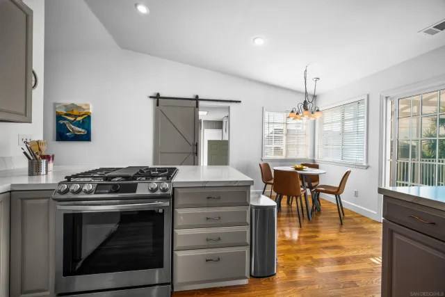 a kitchen with a stove and a table chair