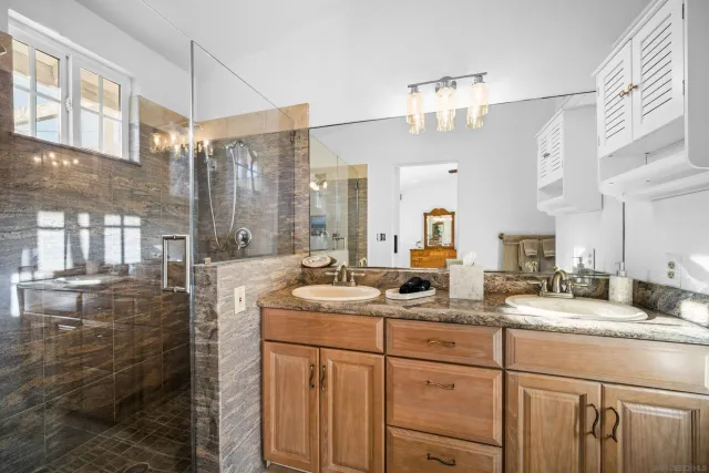 a bathroom with a sink double vanity granite and a mirror