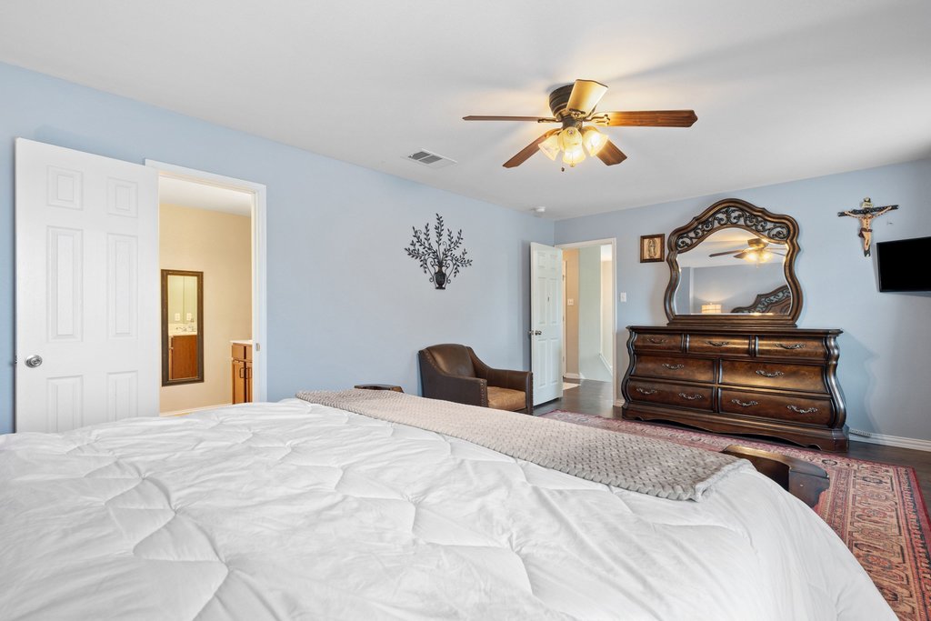 140 Wolfberry Path Buda, TX 78610 - Photo 23 of 35 a bedroom with a bed and a chandelier