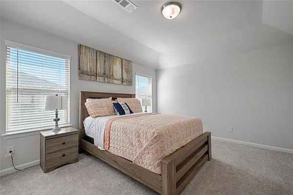 a bed sitting in a bedroom next to a window