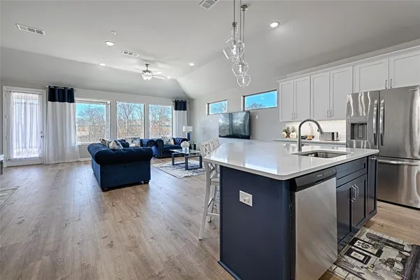 a kitchen with stainless steel appliances granite countertop a sink a stove and a refrigerator