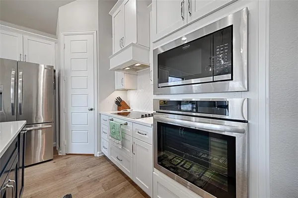 a kitchen with stainless steel appliances a stove a microwave and a refrigerator