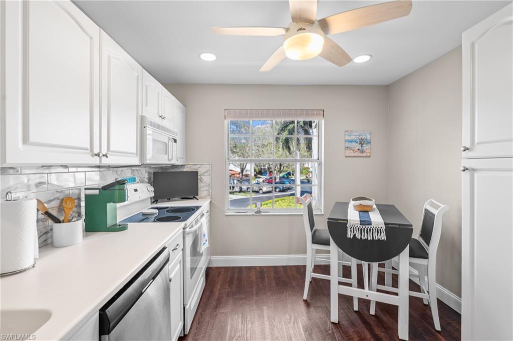 541 Windsor Square Naples, FL 34104 - Photo 7 of 25 a kitchen with stainless steel appliances a dining table chairs and a refrigerator